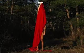 photo of a person in the nature, covered with red fabric